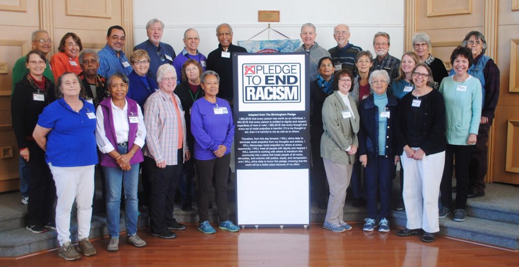 Group around a Pledge to End Racism sign