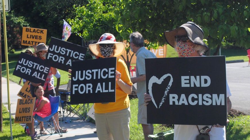 People holding signs that say justice for all, end racism, black lives matter